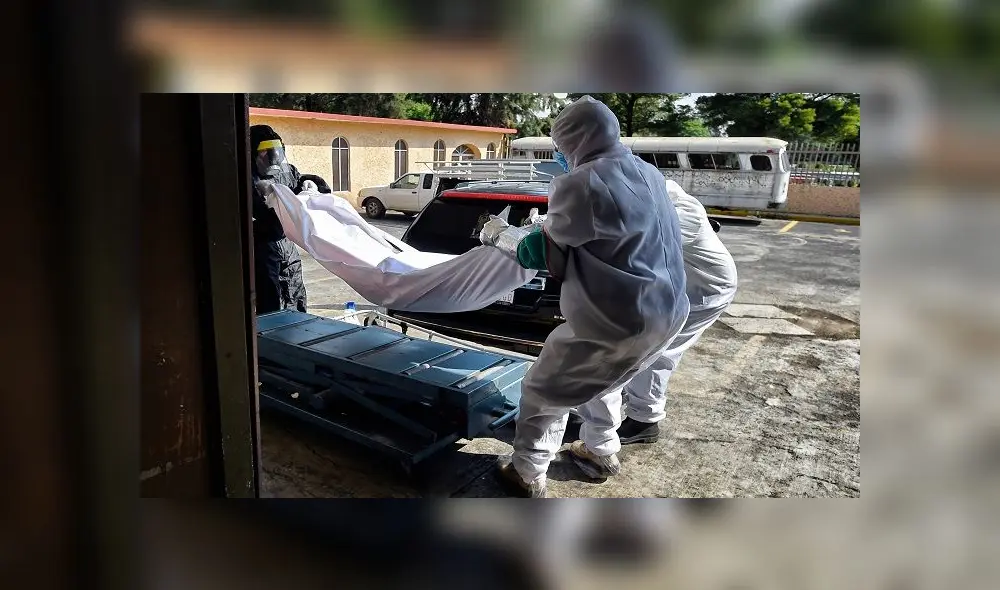 Workers unload the corpse of s suspected COVID-19 victim from a hearse at the San Isidro Pantheon in Azcapotzalco, Mexico City, on June 10, 2020. (Photo by ALFREDO ESTRELLA / AFP)