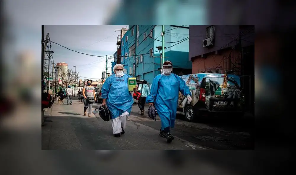 Personal sanitario con trajes de protección caminaban el viernes en la Villa 31 en la ciudad de Buenos Aires. Foto: EFE