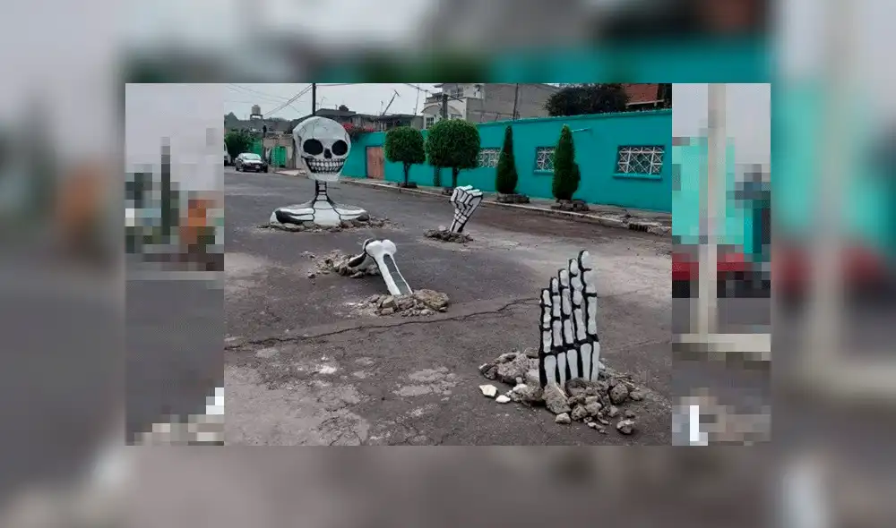 Vecinos utilizan baches en pistas para poner calaveras gigantes [VIDEO]