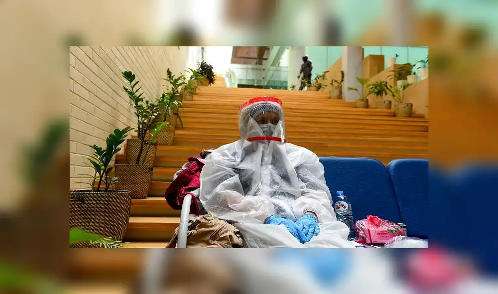 An official wearing protective gear - a measure against the spread of the coronavirus disease - sits on a chair at a polling station in Saint Petersburg's Boris Eifman Dance Palace during a nationwide vote on constitutional reforms on July 1, 2020. (Photo by OLGA MALTSEVA / AFP)