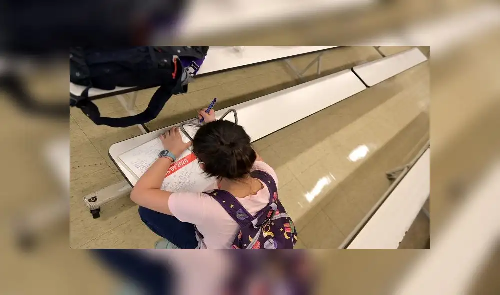 NEW YORK, NEW YORK - JUNE 29: A student who just graduated signs a yearbook that was handed out along with diplomas at Yung Wing School P.S. 124 on June 29, 2020 in New York City. In April, it was announced that NYC public schools would be closed at least through the end of the school year amid the spread of coronavirus (COVID-19). Michael Loccisano/Getty Images/AFP NEW YORK, NEW YORK - JUNE 29: A student who just graduated signs a yearbook that was handed out along with diplomas at Yung Wing School P.S. 124 on June 29, 2020 in New York City. In April, it was announced that NYC public schools would be closed at least through the end of the school year amid the spread of coronavirus (COVID-19). Michael Loccisano/Getty Images/AFP