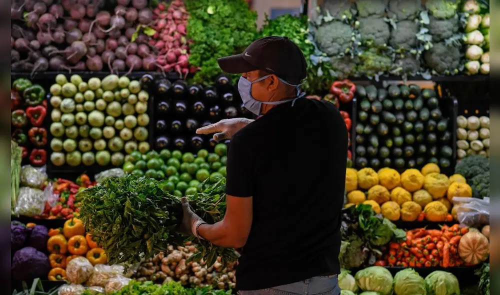 A man wearing a face mask as a preventive measure against the spread of the new coronavirus, COVID-19, buys groceries at a municipal market in Caracas, on March 20, 2020. (Photo by Federico PARRA / AFP) A man wearing a face mask as a preventive measure against the spread of the new coronavirus, COVID-19, buys groceries at a municipal market in Caracas, on March 20, 2020. (Photo by Federico PARRA / AFP)