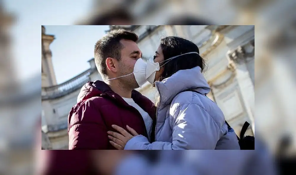 Dos personas se besan con mascarillas por precaución ante la COVID-19. Foto: AFP Dos personas se besan con mascarillas por precaución ante la COVID-19. Foto: AFP