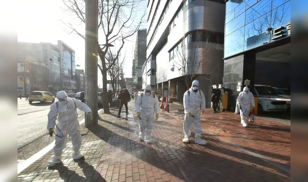 This handout picture taken on February 19, 2020 by Daegu Metropolitan City Namgu shows South Korean health officials wearing protective suit and spraying disinfectant in front of the Daegu branch of the Shincheonji Church of Jesus in the southeastern city of Daegu as about 40 new cases of the COVID-19 coronavirus confirmed after they attended same church services. - A cluster of novel coronavirus infections centred on a cult church in the South Korean city of Daegu leaped to 39 cases February 20, as the country's total spiked for the second successive day. (Photo by Handout / Daegu Metropolitan City Namgu / AFP) / RESTRICTED TO EDITORIAL USE - MANDATORY CREDIT "AFP PHOTO / Daegu Metropolitan City Namgu" - NO MARKETING NO ADVERTISING CAMPAIGNS - DISTRIBUTED AS A SERVICE TO CLIENTS This handout picture taken on February 19, 2020 by Daegu Metropolitan City Namgu shows South Korean health officials wearing protective suit and spraying disinfectant in front of the Daegu branch of the Shincheonji Church of Jesus in the southeastern city of Daegu as about 40 new cases of the COVID-19 coronavirus confirmed after they attended same church services. - A cluster of novel coronavirus infections centred on a cult church in the South Korean city of Daegu leaped to 39 cases February 20, as the country's total spiked for the second successive day. (Photo by Handout / Daegu Metropolitan City Namgu / AFP) / RESTRICTED TO EDITORIAL USE - MANDATORY CREDIT "AFP PHOTO / Daegu Metropolitan City Namgu" - NO MARKETING NO ADVERTISING CAMPAIGNS - DISTRIBUTED AS A SERVICE TO CLIENTS
