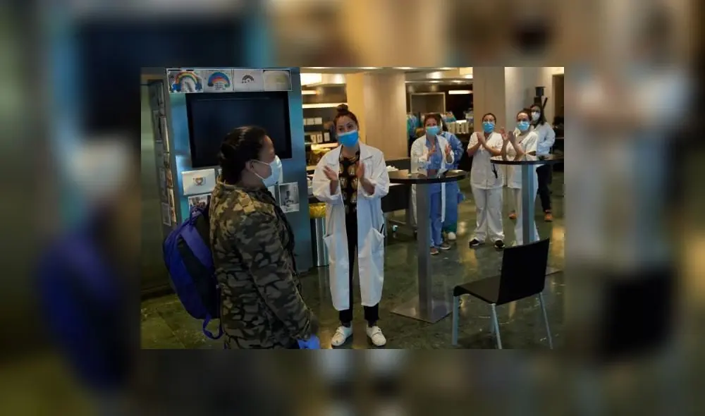 Paciente es despedido con aplausos por parte del personal sanitario en el Hotel Sarria de Barcelona. Foto: EFE.