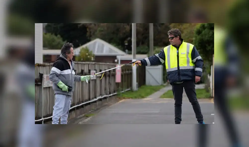 Un guardia de seguridad le da un pase de cita médica a un hombre. Foto: AFP Un guardia de seguridad le da un pase de cita médica a un hombre. Foto: AFP