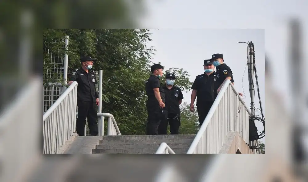 Security personnel stand guard on a pedestrian overpass near the closed Xinfadi market in Beijing on June 13, 2020. - The huge wholesale market has become the centre of focus for a new cluster of coronavirus cases in Beijing, where nervous local officials have begun mass testing, closing schools and neighbourhoods, and turned sharp scrutiny towards the food supply chain. (Photo by GREG BAKER / AFP) Security personnel stand guard on a pedestrian overpass near the closed Xinfadi market in Beijing on June 13, 2020. - The huge wholesale market has become the centre of focus for a new cluster of coronavirus cases in Beijing, where nervous local officials have begun mass testing, closing schools and neighbourhoods, and turned sharp scrutiny towards the food supply chain. (Photo by GREG BAKER / AFP)