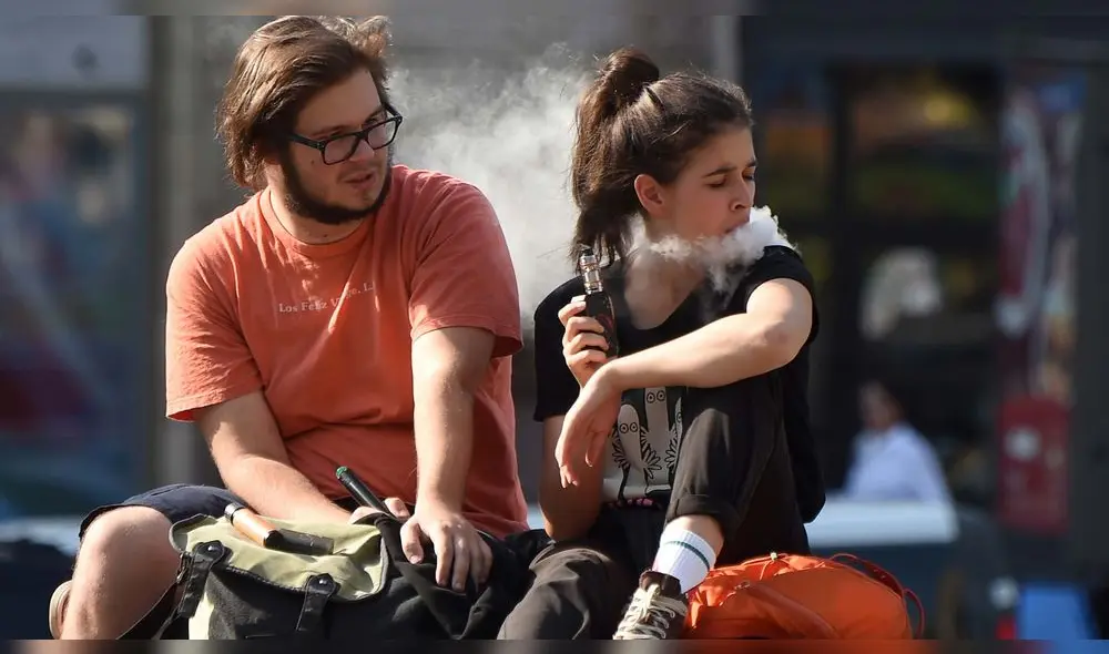 Una pareja fuma cigarrillos electrónicos en el centro de Kiev en un cálido día de otoño el 13 de septiembre de 2019.