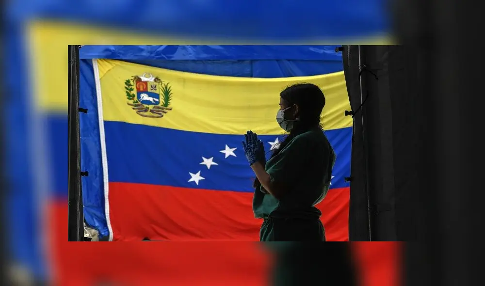 A staff member of Doctors Without Borders prepares herself waits for patients to be tested for COVId-19 in front of a Venezuelan flag at the Perez de Leon Hospital os the Petare neighbourhood, in eastern Caracas on June 23, 2020, amid the new coronavirus pandemic. - In Petare, the largest slum in Venezuela, more than 100 professionals of Doctors Without Borders face the COVID-19 pandemic getting around the crisis in the country's public healthcare sector. (Photo by Federico PARRA / AFP) A staff member of Doctors Without Borders prepares herself waits for patients to be tested for COVId-19 in front of a Venezuelan flag at the Perez de Leon Hospital os the Petare neighbourhood, in eastern Caracas on June 23, 2020, amid the new coronavirus pandemic. - In Petare, the largest slum in Venezuela, more than 100 professionals of Doctors Without Borders face the COVID-19 pandemic getting around the crisis in the country's public healthcare sector. (Photo by Federico PARRA / AFP)
