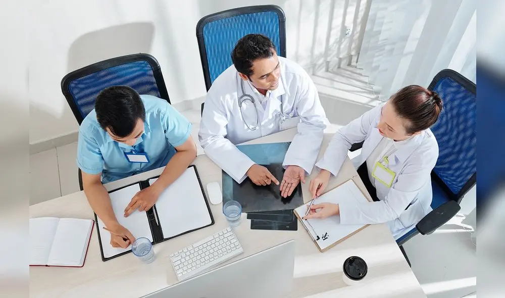 Team of medical workers gathered at big table to discuss outbreak of new disease in the city