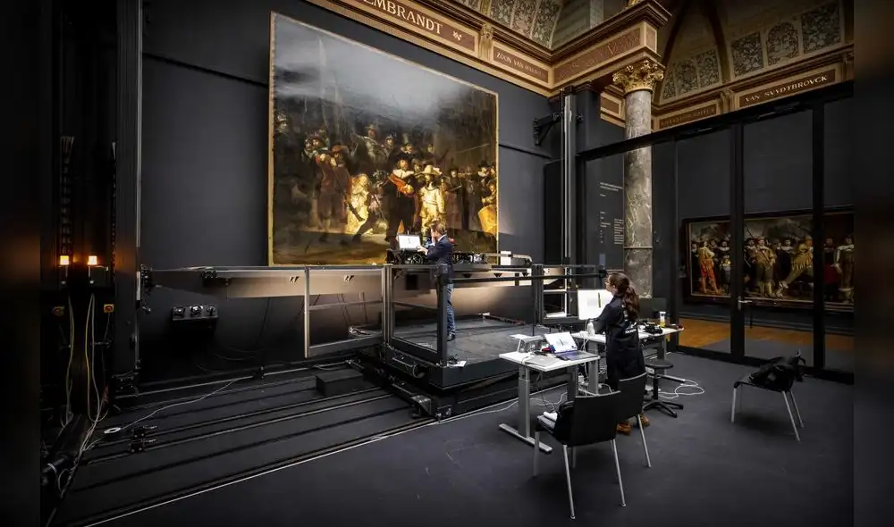 Momentos en que trabajan la fotografía de la pintura "Ronda de Noche" de Rembrandt.