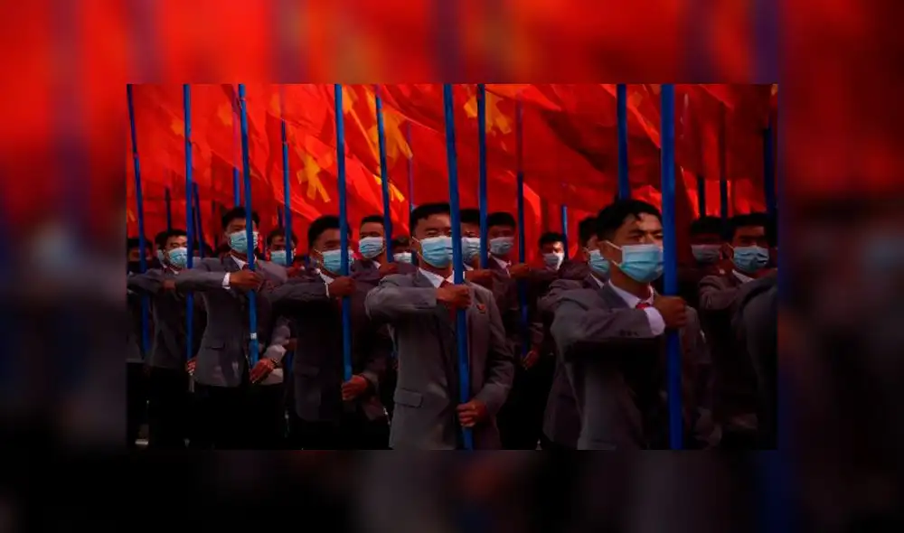 Participantes alzan una gigante bandera de Corea del Norte. Foto: AFP Participantes alzan una gigante bandera de Corea del Norte. Foto: AFP