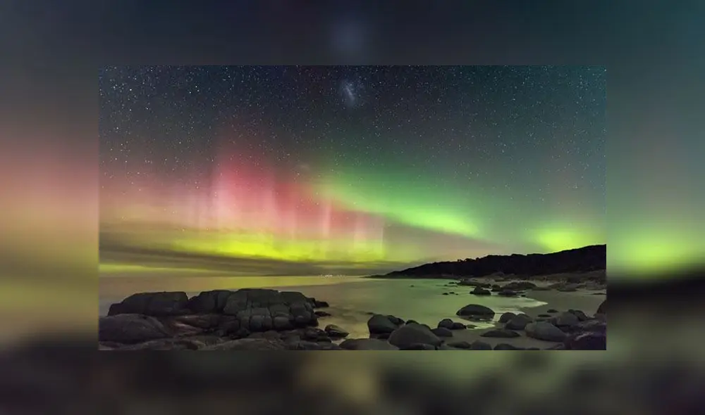 Una exhibición de colores brillantes de las Luces del Sur se proyecta hacia el cielo nocturno en la costa este de Tasmania. La Gran Nube de Magallanes también aparece en el centro superior de la imagen. Foto: James Stone