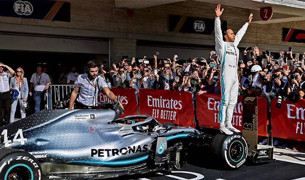 Emocionado. Hamilton celebra sobre un neumático de su coche.