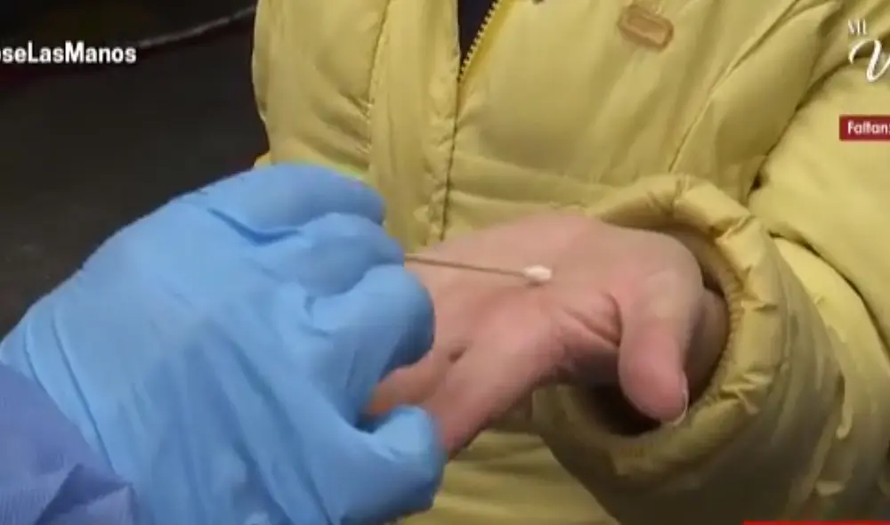 A una mujer se le realizó el hisopado en las manos a las afueras de un mercado en La Victoria. Foto: Captura de Cuarto Poder