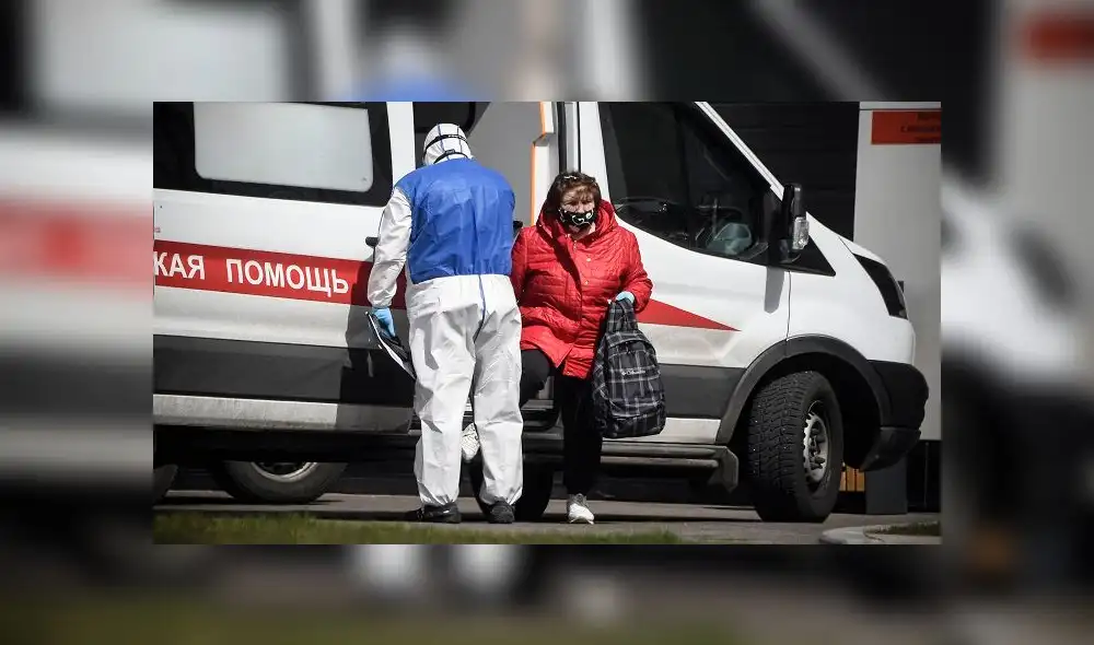 A medic escorts a woman into a hospital where patients infected with the COVID-19 novel coronavirus are being treated in the settlement of Kommunarka outside Moscow on April 28, 2020. (Photo by Alexander NEMENOV / AFP) A medic escorts a woman into a hospital where patients infected with the COVID-19 novel coronavirus are being treated in the settlement of Kommunarka outside Moscow on April 28, 2020. (Photo by Alexander NEMENOV / AFP)