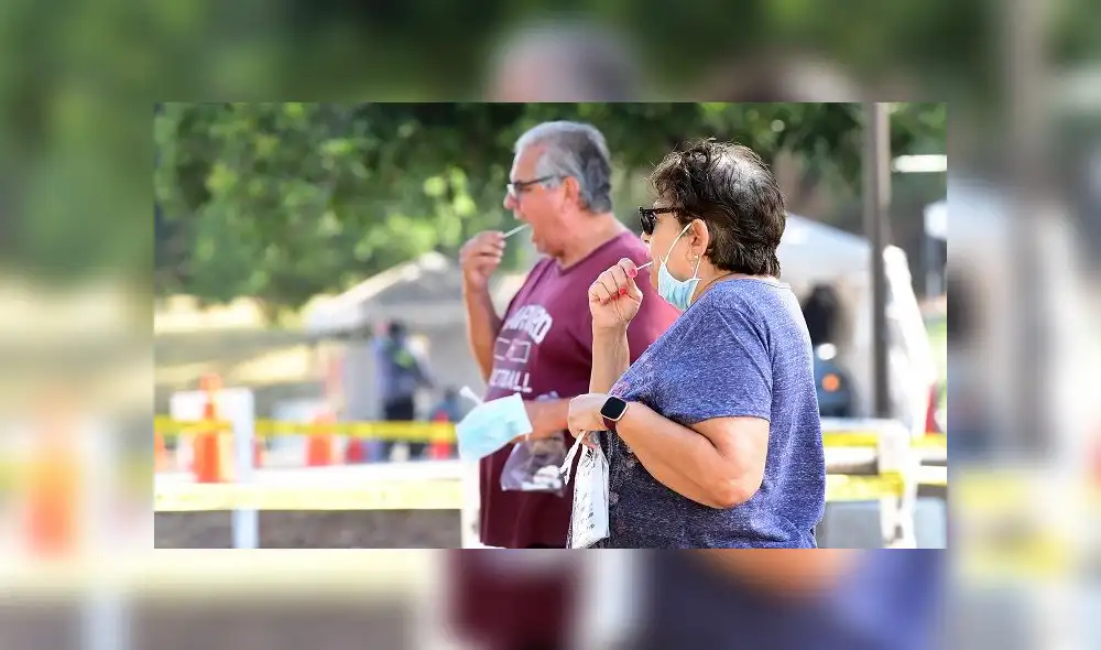 People swab their mouths for the test at a coronavirus testing site in Los Angeles, California on September 4, 2020. - Testing sites for COVID-19 operating in Los Angeles County will close for the Labour Day weekend due to the extreme heat that is forecast to hit southern California. (Photo by Frederic J. BROWN / AFP)