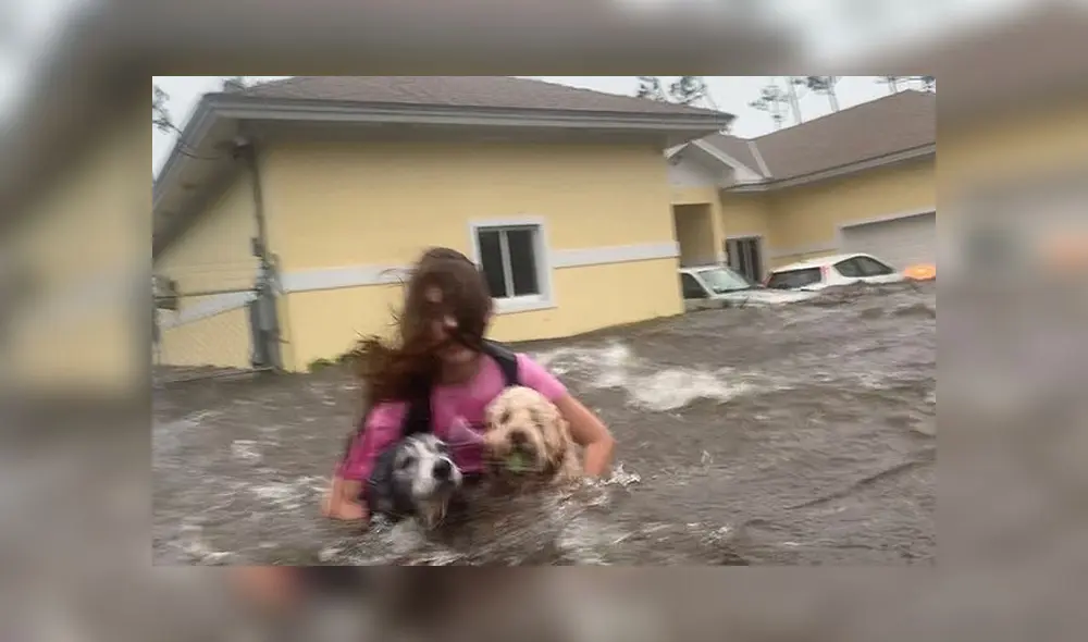 Julia Aylen al rescate de sus dos perros, en plena inundación por el paso del huracán Dorian. Foto: Difusión