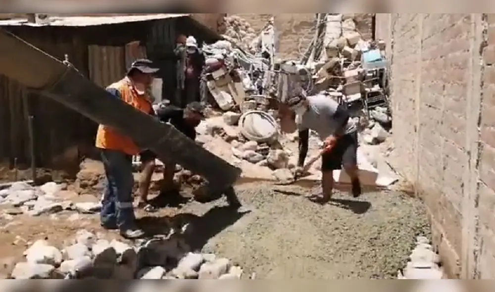 Mientras una mezcladora de cemento iba vaciando el concreto, dos policías esparcían el cemento con palas. Foto: captura video. Mientras una mezcladora de cemento iba vaciando el concreto, dos policías esparcían el cemento con palas. Foto: captura video.