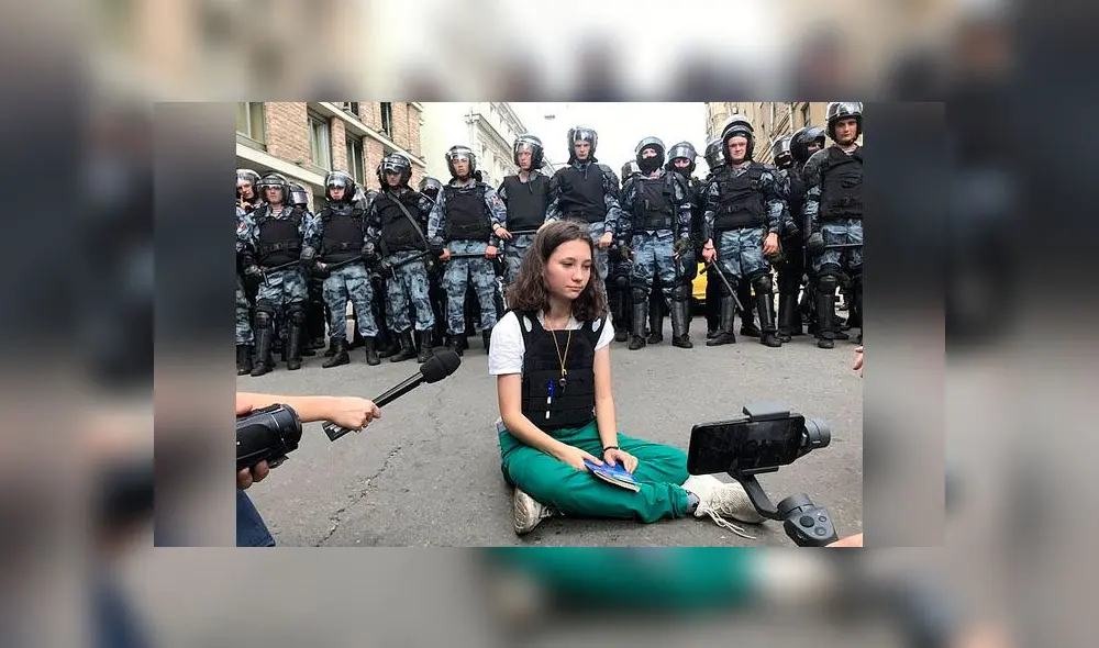 Olga Misik se sienta ante la policía antidisturbios para leer la constitución rusa. Foto: PA. Olga Misik se sienta ante la policía antidisturbios para leer la constitución rusa. Foto: PA.