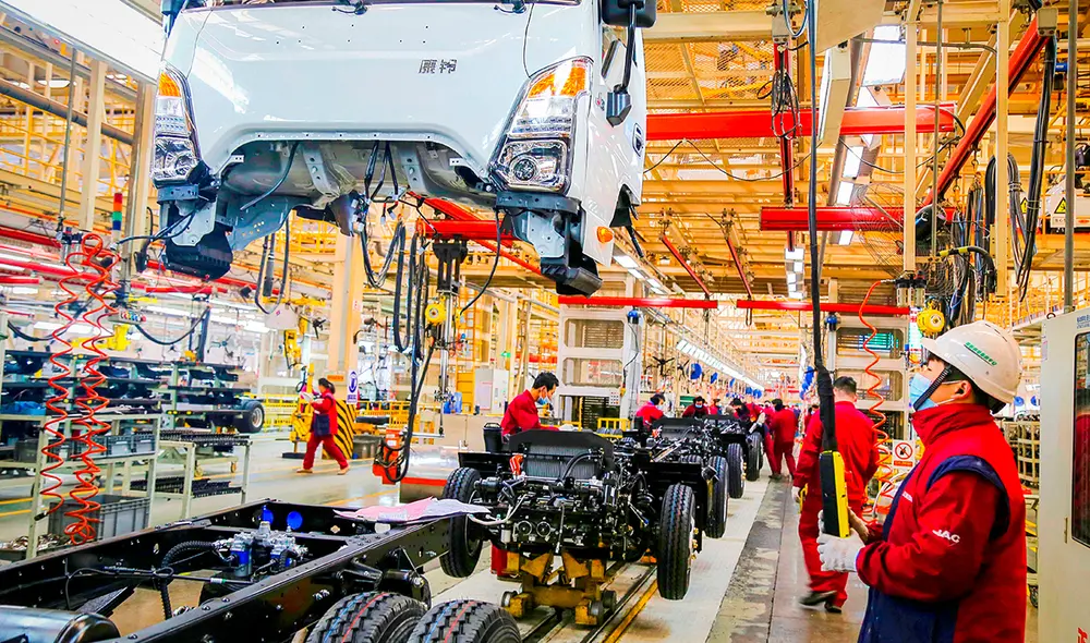 Empleados trabajan en una línea de ensamblaje de camiones en una fábrica de vehículos en Shandong, en el este de China. Foto. AFP