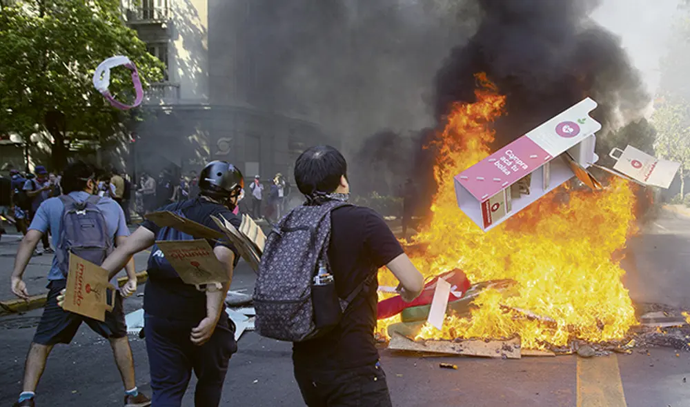 Hoguera. Jóvenes arman barricadas de fuego en una de las calles de Santiago.