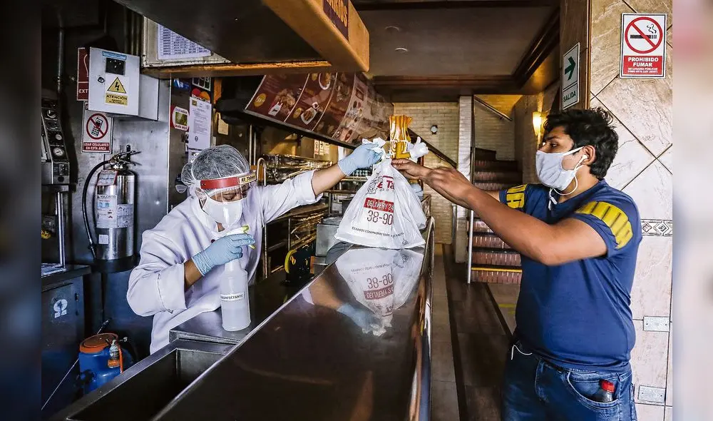 El personal que entrega las bolsas con los alimentos usa nuevos implementos como mascarillas, protectores faciales, guantes y desinfectante. (Foto: Oswald Charca) El personal que entrega las bolsas con los alimentos usa nuevos implementos como mascarillas, protectores faciales, guantes y desinfectante. (Foto: Oswald Charca)