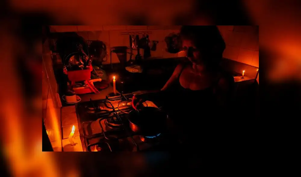 En la ciudad de San Cristóbal una mujer cocina, mientras se ilumina con velas, en un país con apagones constantes. Foto: EFE En la ciudad de San Cristóbal una mujer cocina, mientras se ilumina con velas, en un país con apagones constantes. Foto: EFE