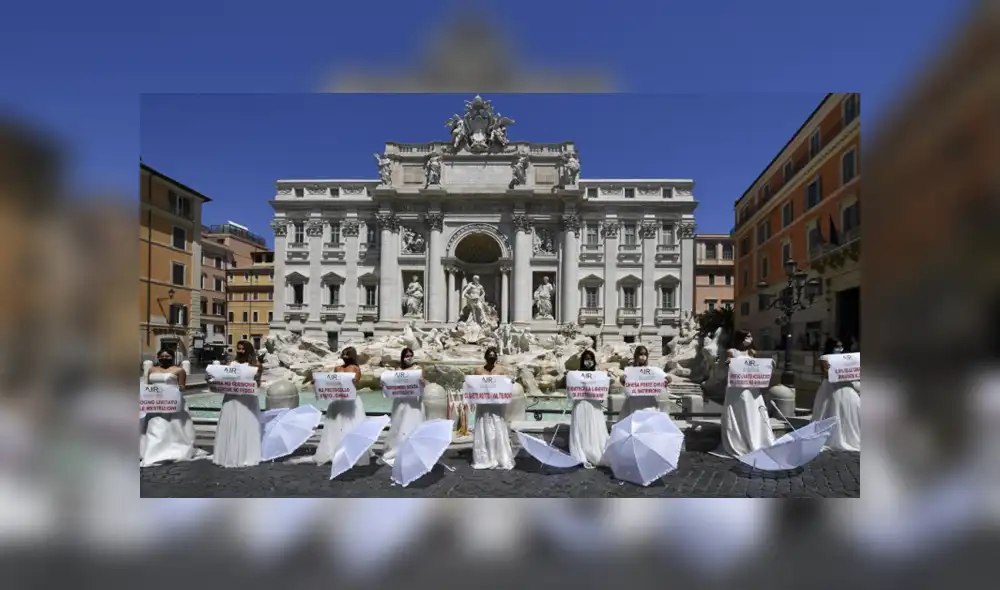 Las mujeres se presentaron con carteles y sombrillas blancas para reclamar las "estrictas" medidas del Gobierno italiano. Foto: AFP.
