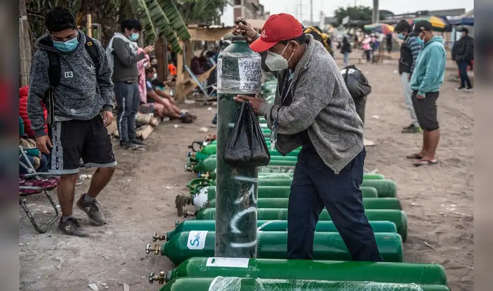 A man carries an empty oxygen tank as he arrives to queue to refill it in Villa El Salvador, on the southern outskirts of Lima, on April 11, 2021, amid the COVID-19 coronavirus pandemic. - Relatives of COVID-19 patients are desperate for oxygen to keep their loved ones alive during a fierce second wave of the pandemic in Peru, during the day of the first round of presidential and parliamentary elections. (Photo by ERNESTO BENAVIDES / AFP) A man carries an empty oxygen tank as he arrives to queue to refill it in Villa El Salvador, on the southern outskirts of Lima, on April 11, 2021, amid the COVID-19 coronavirus pandemic. - Relatives of COVID-19 patients are desperate for oxygen to keep their loved ones alive during a fierce second wave of the pandemic in Peru, during the day of the first round of presidential and parliamentary elections. (Photo by ERNESTO BENAVIDES / AFP)