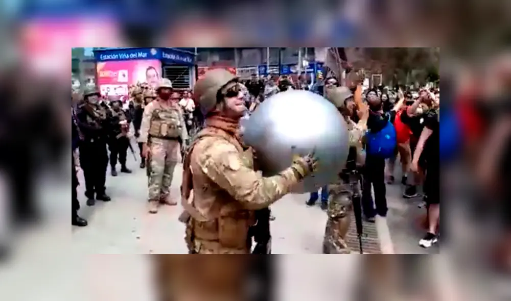 Militares y manifestantes juegan con pelota de playa en plena marcha.