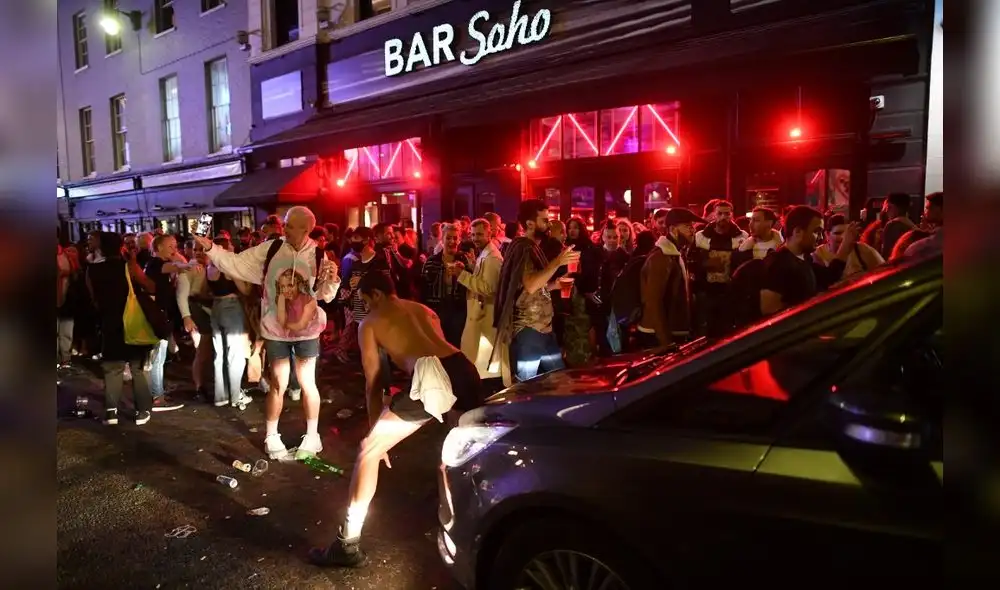 Auto intenta cruzar calle llena de juerguistas que beben en el área de Soho de Londres. Foto: AFP. Auto intenta cruzar calle llena de juerguistas que beben en el área de Soho de Londres. Foto: AFP.