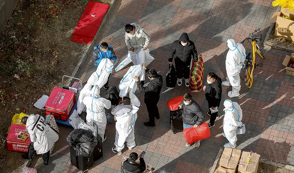 Contagiados. Agentes de seguridad y de salubridad controlan
a la población y trasladan el cuerpo de una víctima de la COVID. Foto EFE Contagiados. Agentes de seguridad y de salubridad controlan
a la población y trasladan el cuerpo de una víctima de la COVID. Foto EFE