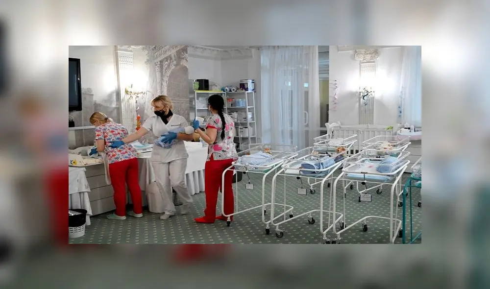 Nurses care for newborn babies at Kiev's Venice hotel on May 15, 2020. - More than 100 babies born to surrogate mothers have been stranded in Ukraine as their foreign parents cannot collect them due to border closures imposed during the coronavirus pandemic, authorities said on May 14. (Photo by Sergei SUPINSKY / AFP)