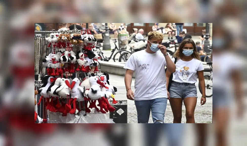People wearing face masks pass by a gift shop on May 22, 2020 in Strasbourg, eastern France, after the city of Strasbourg on May 20, issued a decree making the wearing of masks "obligatory" in the city centre at the busiest hours of the day. (Photo by FREDERICK FLORIN / AFP)