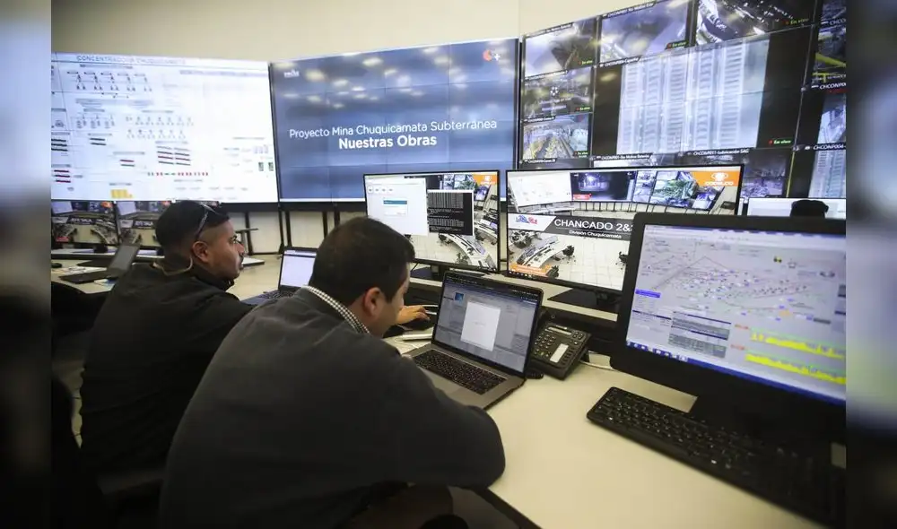 Dos hombres trabajan en el Centro Integrado de Operaciones y Gestión de la mina subterránea de cobre Chuquicamata, en Antofagasta (Chile). Foto: EFE