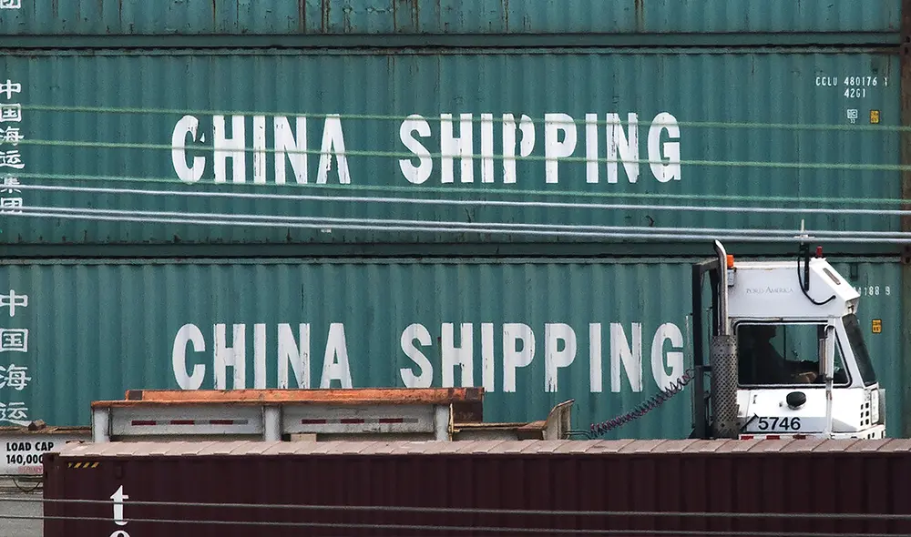 Un camión pasa por contenedores de China Shipping en el puerto de Los Ángeles, tras la imposición de nuevos aranceles a las importaciones chinas, en California. Foto: AFP