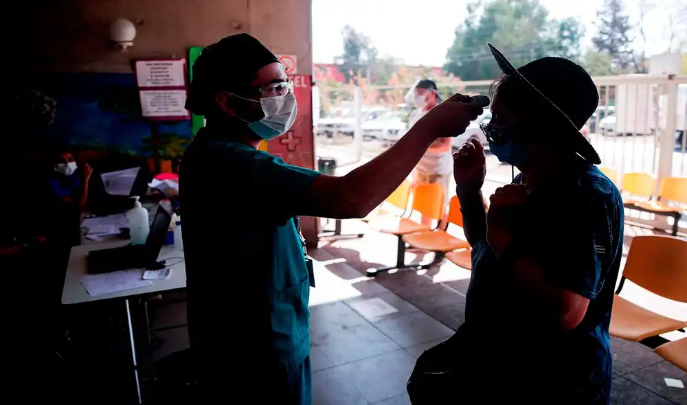 Un enfermero toma la temperatura a una mujer antes de su ingreso a un centro de salud en Santiago (Chile), donde el coronavirus se ha expandido. Foto: EFE Un enfermero toma la temperatura a una mujer antes de su ingreso a un centro de salud en Santiago (Chile), donde el coronavirus se ha expandido. Foto: EFE