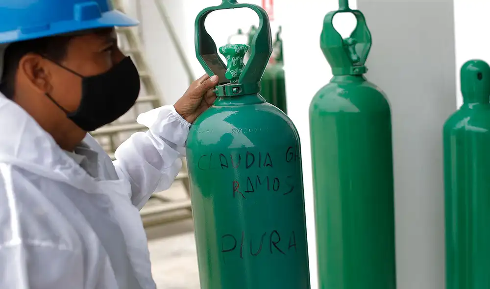 Un trabajador con una bala de oxígeno ya usada por un paciente COVID-19, y en la que se ve el nombre de la persona beneficiada. Foto: EFE Un trabajador con una bala de oxígeno ya usada por un paciente COVID-19, y en la que se ve el nombre de la persona beneficiada. Foto: EFE
