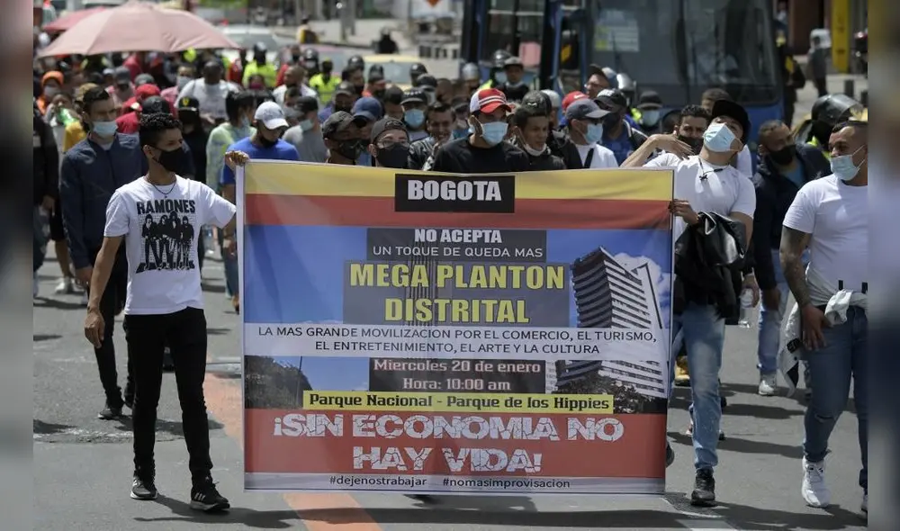 Convocados por gremios de comerciantes, artistas y vendedores informales marcharon antes del toque de queda nocturno que rige en Bogotá, Cali y Medellín. Foto: AFP