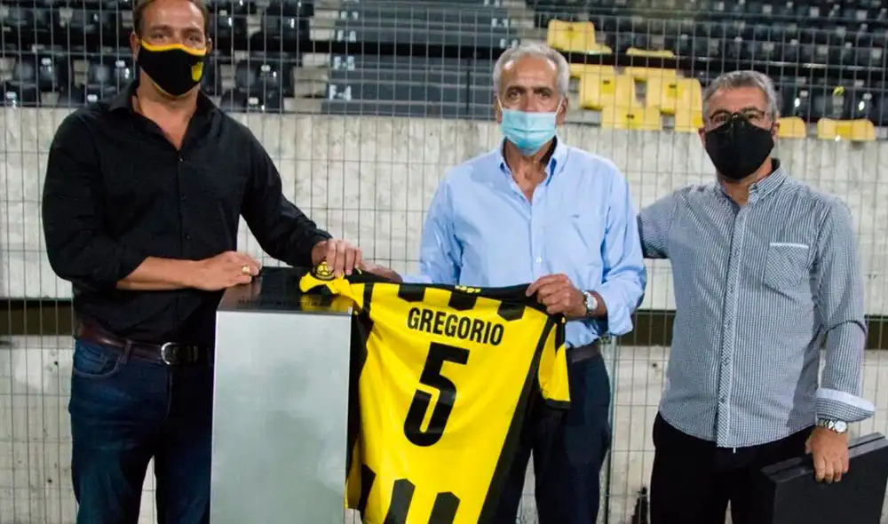 Gregorio Pérez, exDT de Universitario, recibió una distinción por parte de Pablo Bengoechea, actual director deportivo de Peñarol. Foto: Peñarol/Twitter