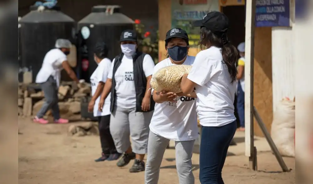 Vecinos de la olla común La Esperanza, de Villa María del Triunfo, recibiendo víveres recolectados por el colectivo Manos a la Olla. Foto: Jorge Cerdán. Vecinos de la olla común La Esperanza, de Villa María del Triunfo, recibiendo víveres recolectados por el colectivo Manos a la Olla. Foto: Jorge Cerdán.