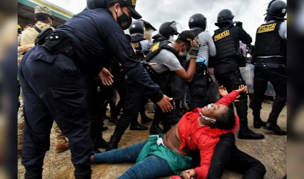 Una policía intenta levantar a una mujer en medio del caos que provocó, el martes 16, el abrupto ingreso de cientos de migrantes a Iñapari, en Madre de Dios. Los extranjeros fueron retornados a Brasil por la Policía. Foto: EFE. Una policía intenta levantar a una mujer en medio del caos que provocó, el martes 16, el abrupto ingreso de cientos de migrantes a Iñapari, en Madre de Dios. Los extranjeros fueron retornados a Brasil por la Policía. Foto: EFE.
