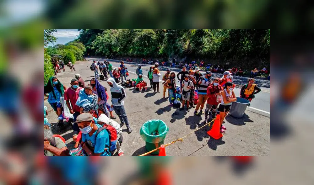 Migrantes venezolanos usan mascarillas mientras hacen cola para recibir alimentos y medicinas de miembros de la Cruz Roja en una carretera en Cúcuta, Colombia. Foto: AFP