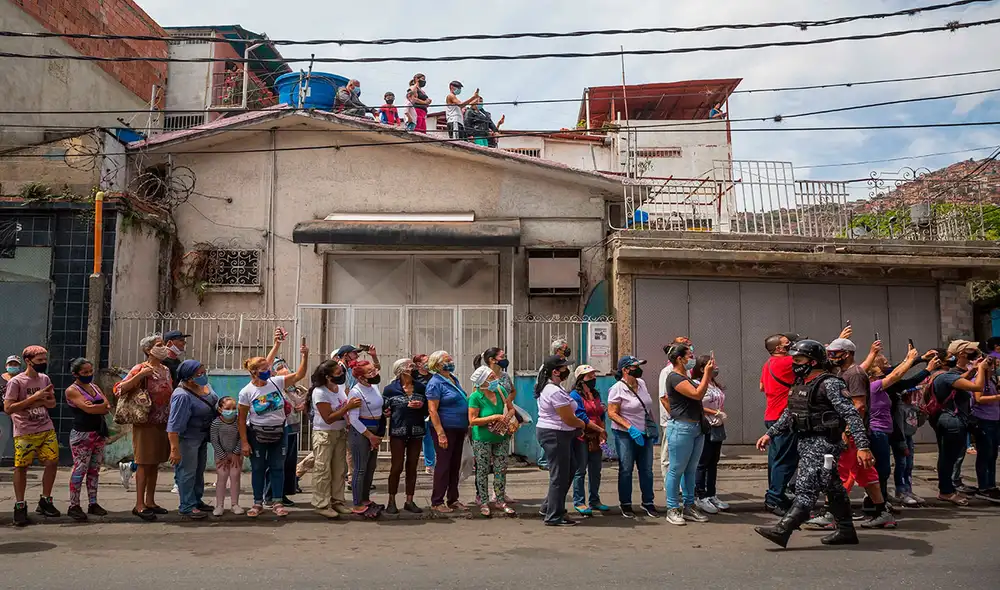 Fieles católicos protegidos durante la advocación de Jesucristo, el Nazareno de San Pablo. Tras el Bono Semana Santa, ahora activaron otro en el sistema Patria. Foto: AFP