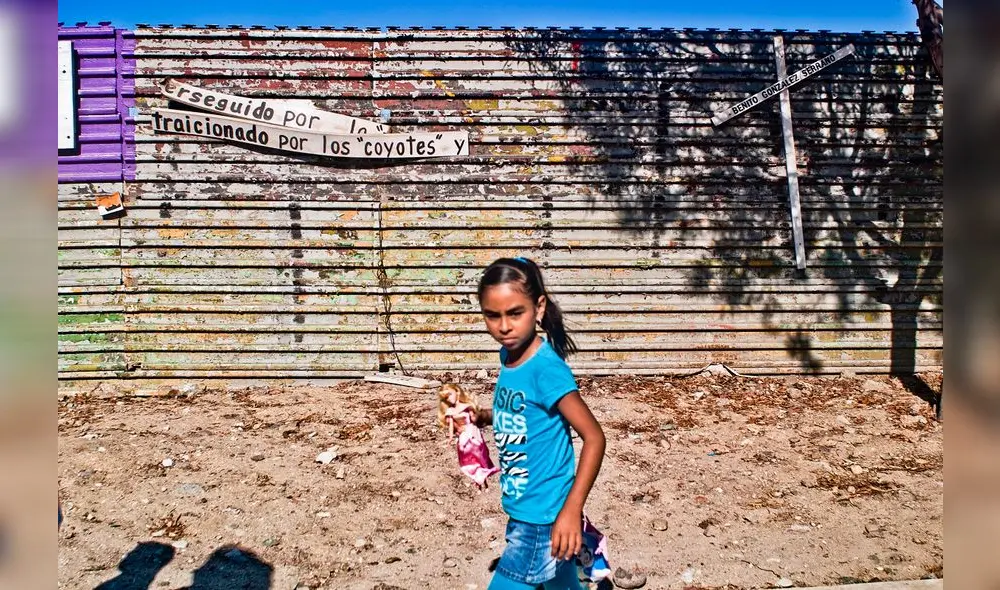 Niña camina junto a mensaje que cuestiona a traficantes de personas. Niña camina junto a mensaje que cuestiona a traficantes de personas.