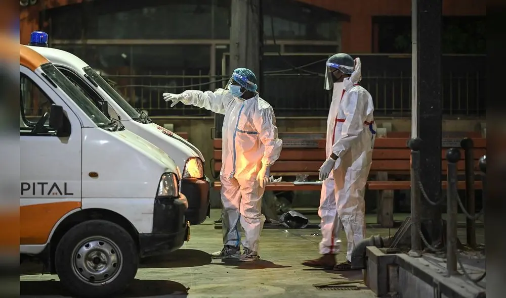 Los miembros del personal del crematorio se paran cerca de las ambulancias que transporta cuerpos de las víctimas de la COVID-19 en India. Foto: AFP Los miembros del personal del crematorio se paran cerca de las ambulancias que transporta cuerpos de las víctimas de la COVID-19 en India. Foto: AFP