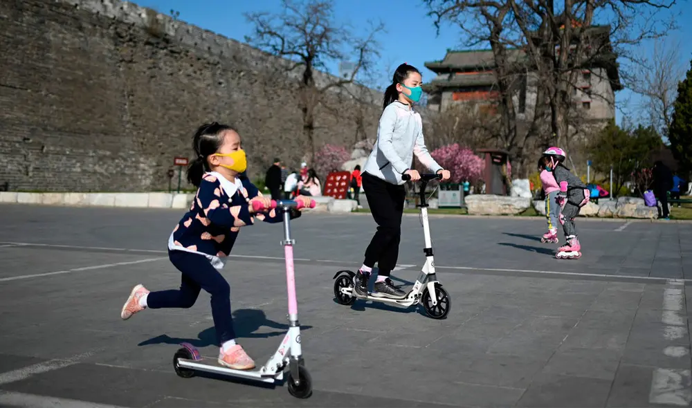 Niños con mascarilla juegan en un parque de Wuhan, China. Foto: AFP Niños con mascarilla juegan en un parque de Wuhan, China. Foto: AFP
