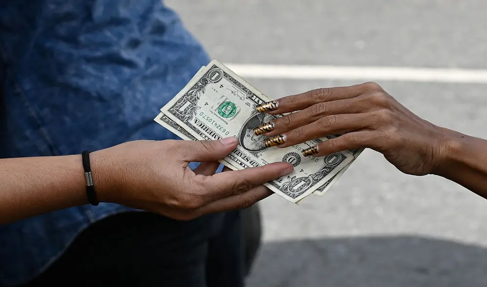 En Venezuela cada vez se usan más los dólares y se reseña la tasa oficial del BCV. Foto: AFP En Venezuela cada vez se usan más los dólares y se reseña la tasa oficial del BCV. Foto: AFP