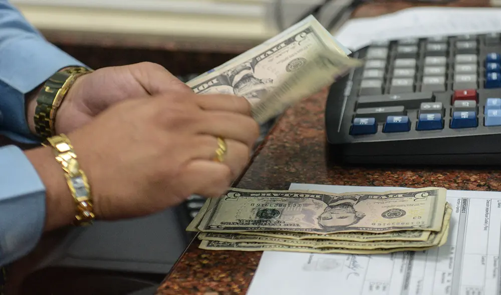 En Venezuela, un país sumido en grave crisis, gran cantidad de personas revisan el precio del dólar del Banco Central de Venezuela. Foto: AFP En Venezuela, un país sumido en grave crisis, gran cantidad de personas revisan el precio del dólar del Banco Central de Venezuela. Foto: AFP